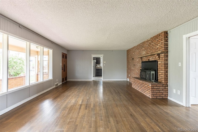1345 Laredo St, Aurora, CO 80011 - unfurnished living room with a textured ceiling, baseboards, visible vents, and wood finished floors