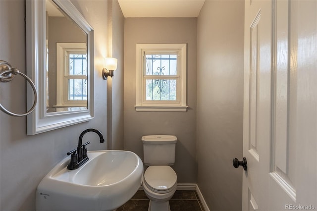 1345 Laredo St, Aurora, CO 80011 - bathroom featuring toilet, baseboards, tile patterned flooring, and a sink