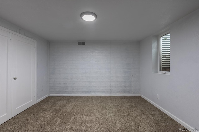 1345 Laredo St, Aurora, CO 80011 - carpeted empty room with visible vents, baseboards, and brick wall