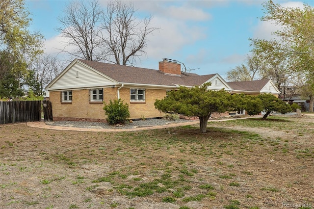 1345 Laredo St, Aurora, CO 80011 - exterior space featuring a chimney, roof with shingles, brick siding, and fence