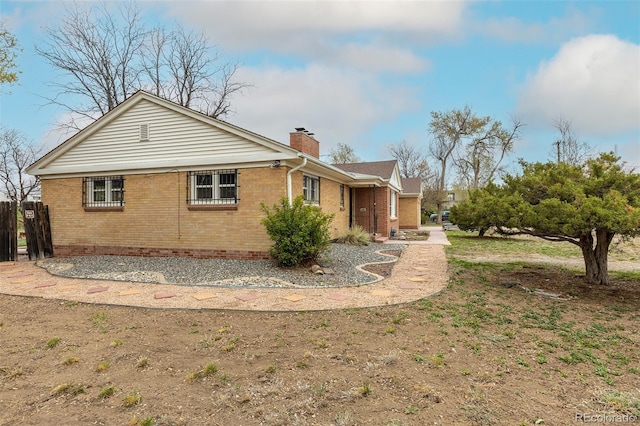 1345 Laredo St, Aurora, CO 80011 - view of property exterior featuring fence, a chimney, and brick siding
