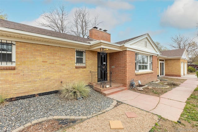 1345 Laredo St, Aurora, CO 80011 - exterior space featuring a chimney, brick siding, and a shingled roof