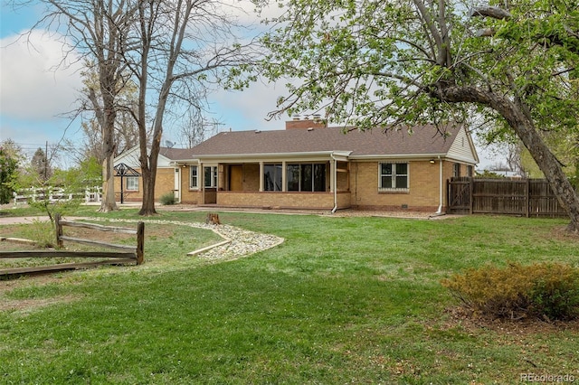 1345 Laredo St, Aurora, CO 80011 - back of property featuring a yard, a chimney, brick siding, and fence