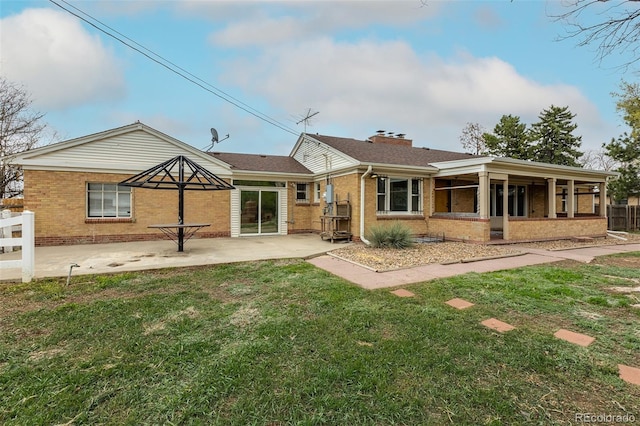 1345 Laredo St, Aurora, CO 80011 - back of property with brick siding, fence, a lawn, and a patio area