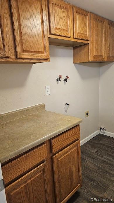 washroom featuring baseboards, cabinet space, dark wood-style flooring, and washer hookup