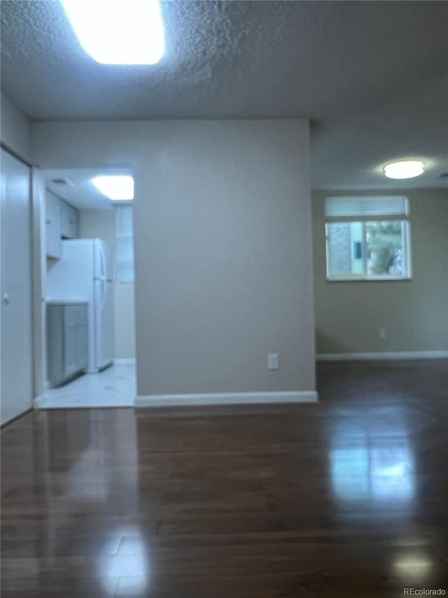 empty room featuring baseboards and a textured ceiling