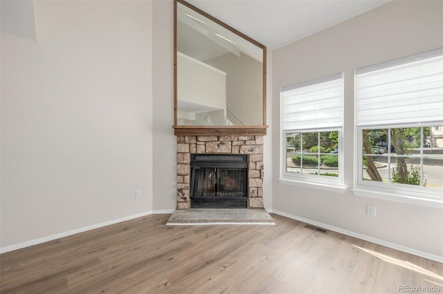 3912 S Richfield Way, Aurora, CO 80013 - unfurnished living room with wood finished floors, a stone fireplace, vaulted ceiling, and baseboards