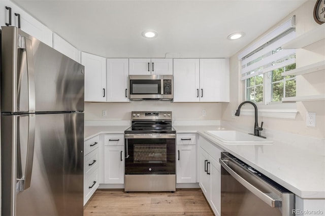3912 S Richfield Way, Aurora, CO 80013 - kitchen with stainless steel appliances, a sink, recessed lighting, white cabinetry, and light countertops