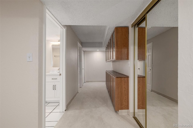 3912 S Richfield Way, Aurora, CO 80013 - corridor featuring a textured ceiling, baseboards, and light colored carpet