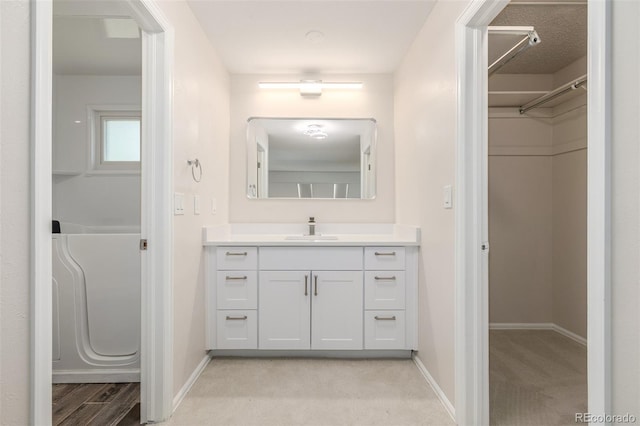 3912 S Richfield Way, Aurora, CO 80013 - bathroom with vanity, baseboards, and a walk in closet
