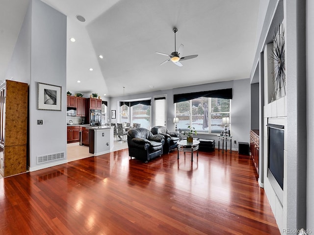 living room featuring ceiling fan, high vaulted ceiling, and wood-type flooring