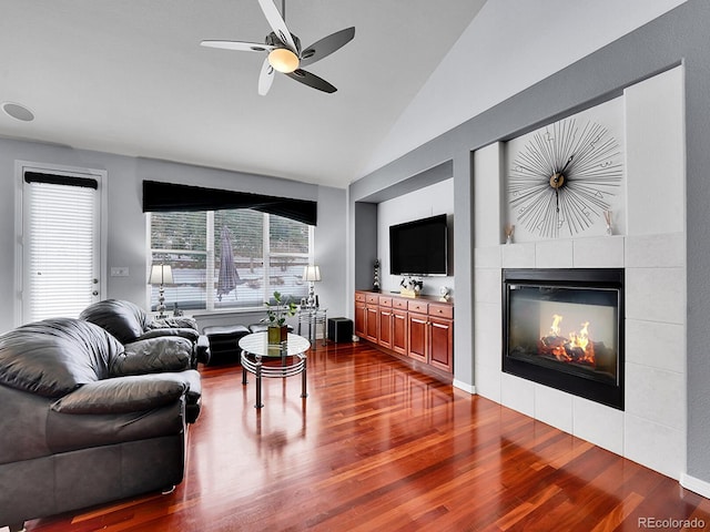 living room with hardwood / wood-style floors, ceiling fan, lofted ceiling, and a tile fireplace