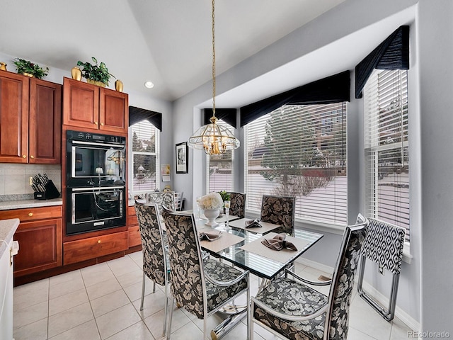 dining area with light tile patterned flooring and a chandelier