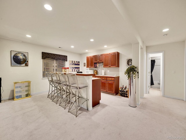 kitchen with a center island, a kitchen bar, and light colored carpet