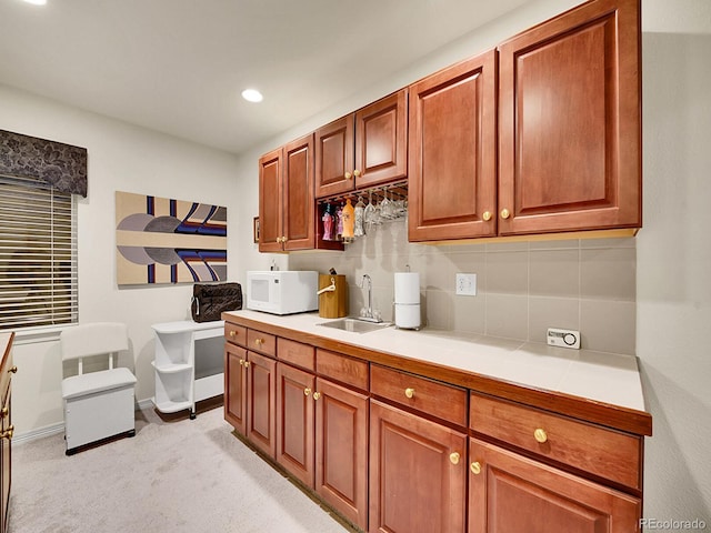 kitchen featuring tasteful backsplash, light carpet, and sink