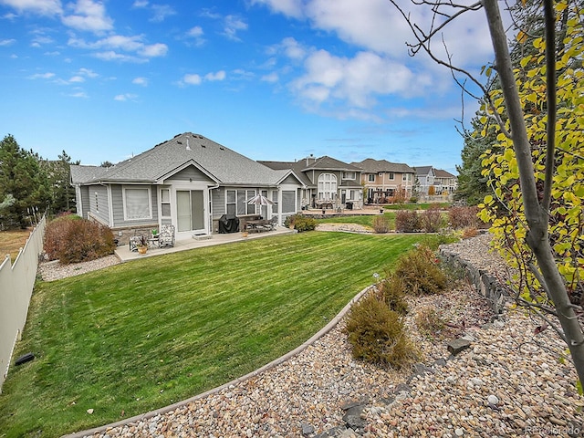 rear view of property featuring a yard and a patio