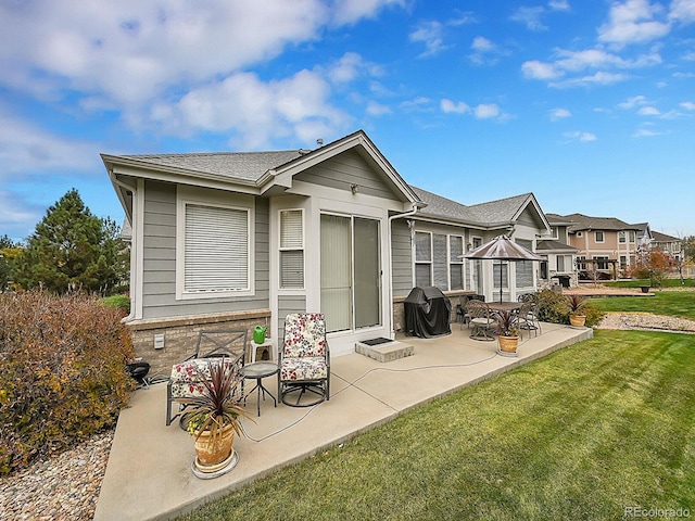 back of property with a lawn and a patio