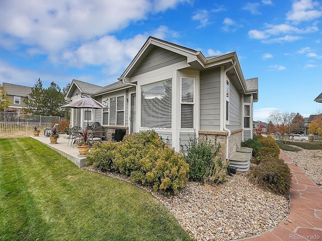 view of home's exterior with a patio and a lawn