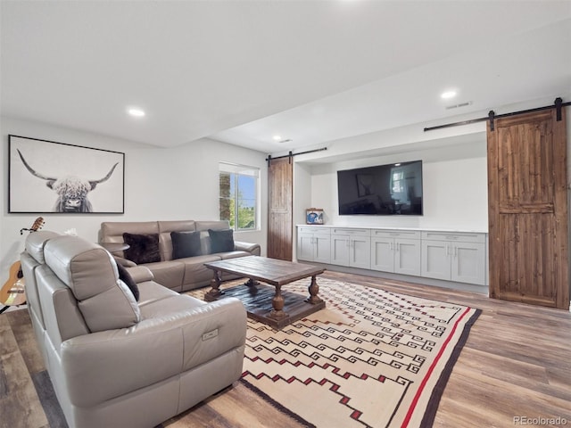 3056 Yale Dr, Broomfield, CO 80023 - living room featuring a barn door, wood finished floors, and recessed lighting