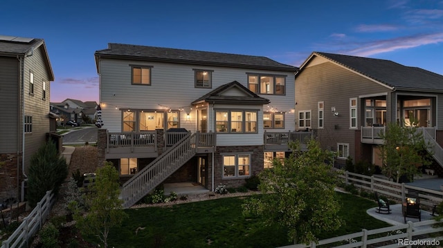 3056 Yale Dr, Broomfield, CO 80023 - back of house at dusk featuring stairs and a wooden deck