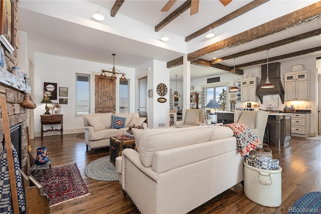 living room with ceiling fan, a fireplace, dark hardwood / wood-style floors, and beam ceiling