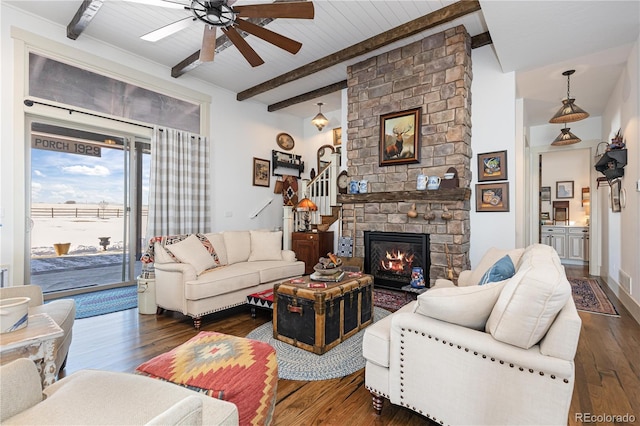 living room with beam ceiling, a fireplace, dark hardwood / wood-style floors, and ceiling fan