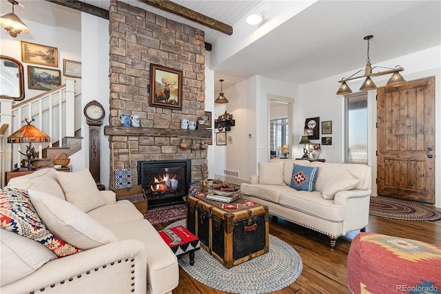 living room featuring beamed ceiling, a stone fireplace, and dark hardwood / wood-style floors