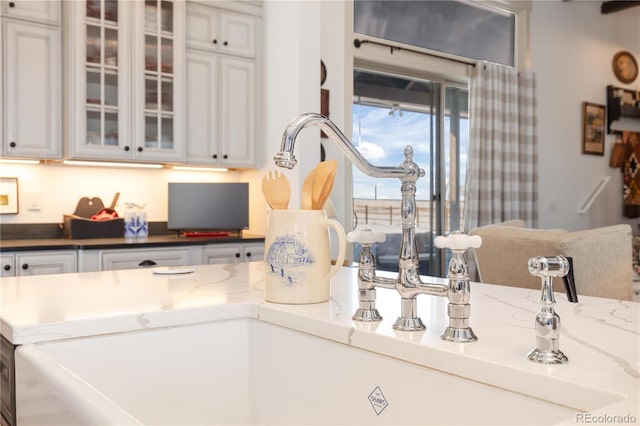 kitchen featuring white cabinetry and dark stone countertops