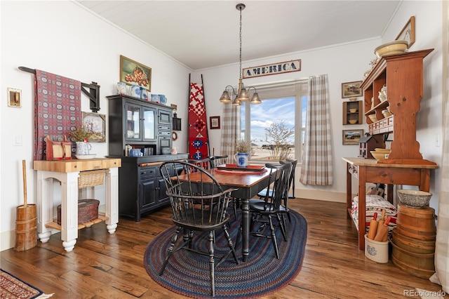 dining area with crown molding, dark hardwood / wood-style floors, and a notable chandelier