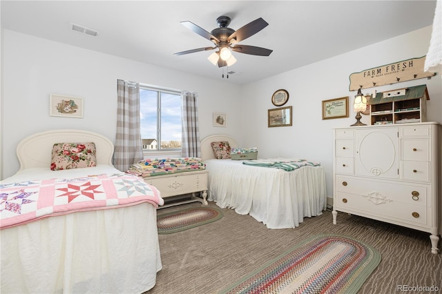 bedroom with dark colored carpet and ceiling fan