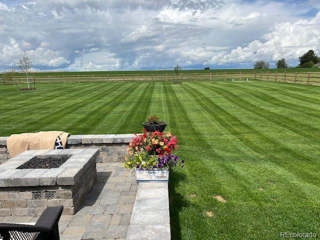 view of yard featuring a rural view, a patio area, and an outdoor fire pit