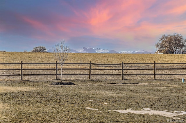 gate at dusk featuring a mountain view and a rural view