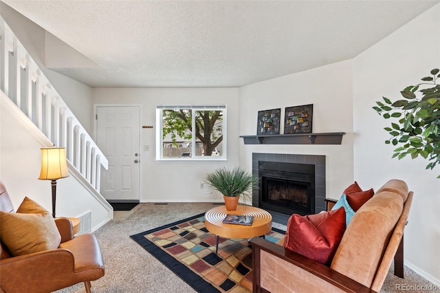 1275 Soaring Eagle Dr, Colorado Springs, CO 80915 - carpeted living room featuring stairway, a tiled fireplace, and a textured ceiling