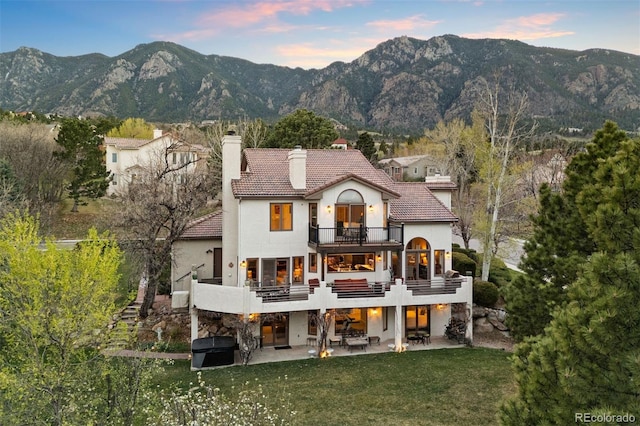150 Chantrey Ct, Colorado Springs, CO 80906 - back of house featuring a balcony, a patio, stucco siding, a chimney, and a tile roof