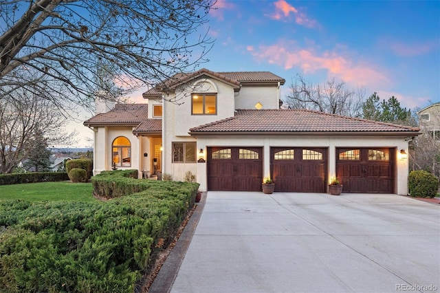 150 Chantrey Ct, Colorado Springs, CO 80906 - mediterranean / spanish house featuring a garage, stucco siding, a tiled roof, concrete driveway, and a yard