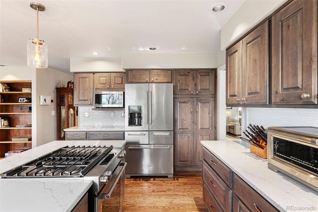 150 Chantrey Ct, Colorado Springs, CO 80906 - kitchen featuring pendant lighting, light stone countertops, stainless steel appliances, and backsplash