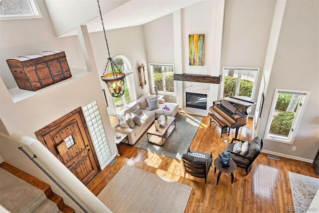 150 Chantrey Ct, Colorado Springs, CO 80906 - living room featuring high vaulted ceiling, a fireplace, wood finished floors, and a wealth of natural light
