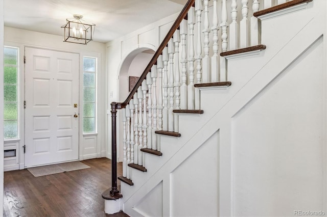 foyer featuring dark wood-type flooring and a notable chandelier