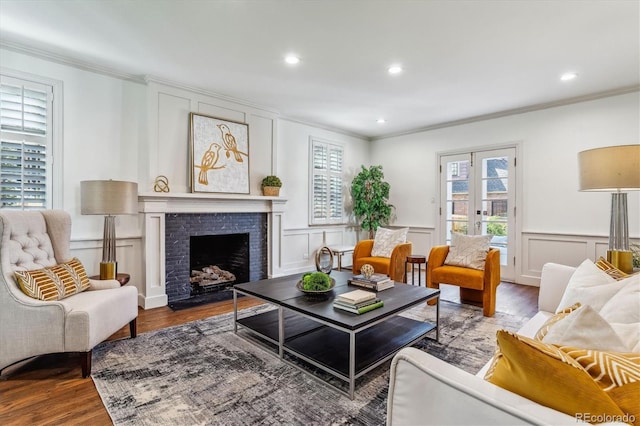 living room featuring a fireplace, light hardwood / wood-style floors, and crown molding