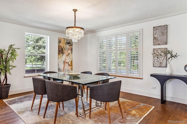 dining area featuring dark hardwood / wood-style flooring, ornamental molding, and a chandelier