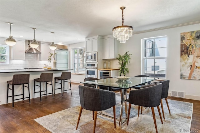 dining area with crown molding, wine cooler, dark hardwood / wood-style floors, a textured ceiling, and a notable chandelier