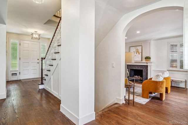 interior space featuring dark hardwood / wood-style flooring and a brick fireplace