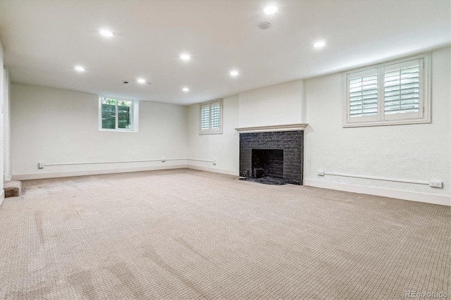 basement with light carpet and a brick fireplace