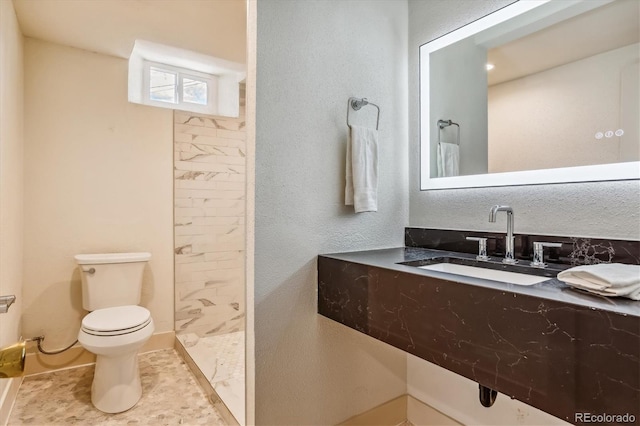 bathroom featuring a shower, toilet, and sink