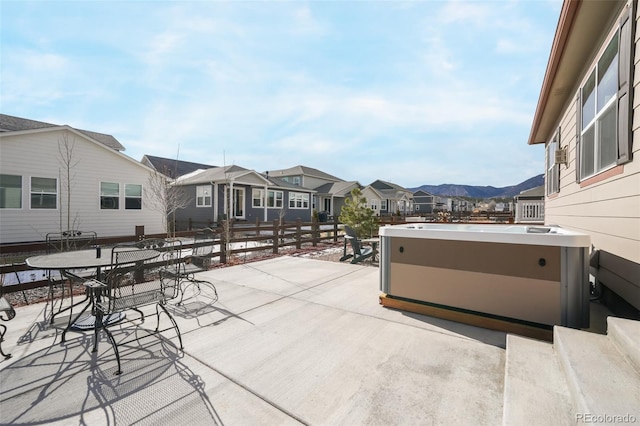 view of patio with a mountain view and a hot tub