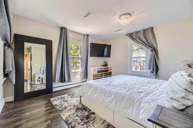 235 W Lehigh Ave, Englewood, CO 80110 - bedroom with a baseboard radiator, dark wood-style flooring, and multiple windows
