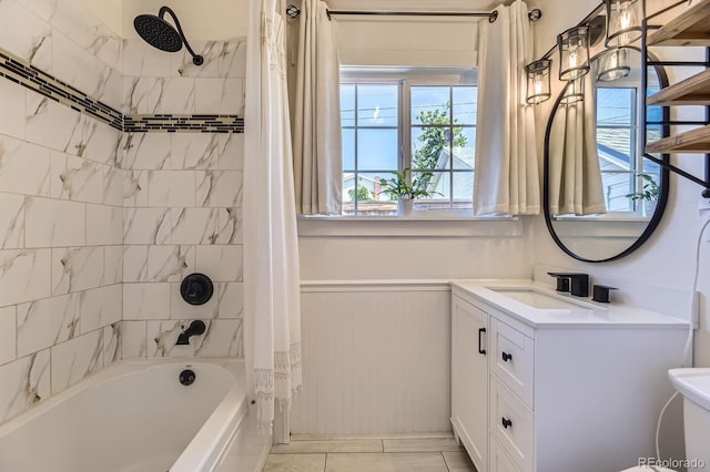 235 W Lehigh Ave, Englewood, CO 80110 - bathroom featuring shower / tub combo, vanity, plenty of natural light, and a wainscoted wall