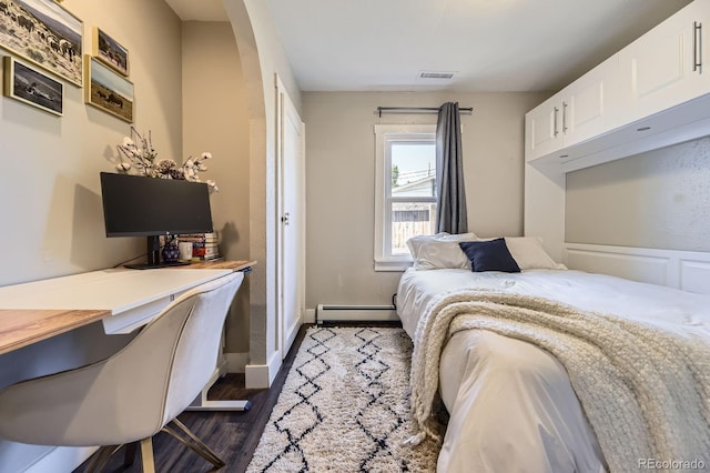 235 W Lehigh Ave, Englewood, CO 80110 - bedroom featuring dark wood finished floors, baseboard heating, a desk, and arched walkways