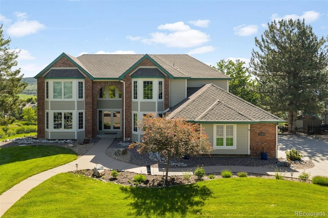 50 Deerwood Dr, Littleton, CO 80127 - view of front facade featuring a front lawn, roof with shingles, brick siding, and french doors