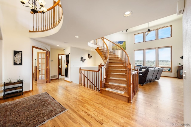 50 Deerwood Dr, Littleton, CO 80127 - staircase featuring a high ceiling, wood finished floors, recessed lighting, a chandelier, and baseboards